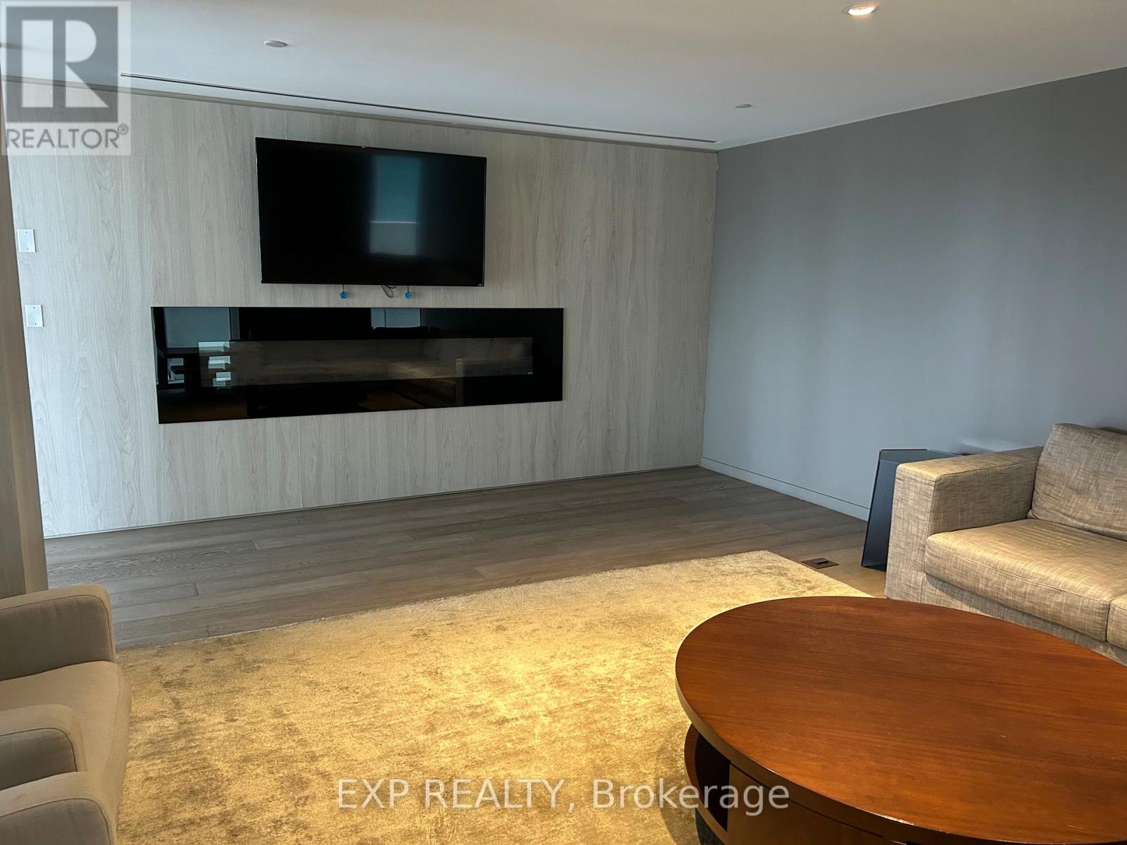 A living room with a flat screen TV mounted on the wall.