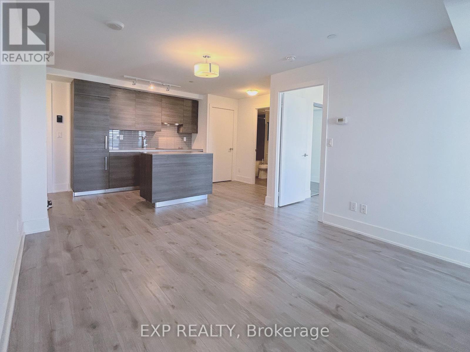 A room with a wooden floor and a grey wall.
