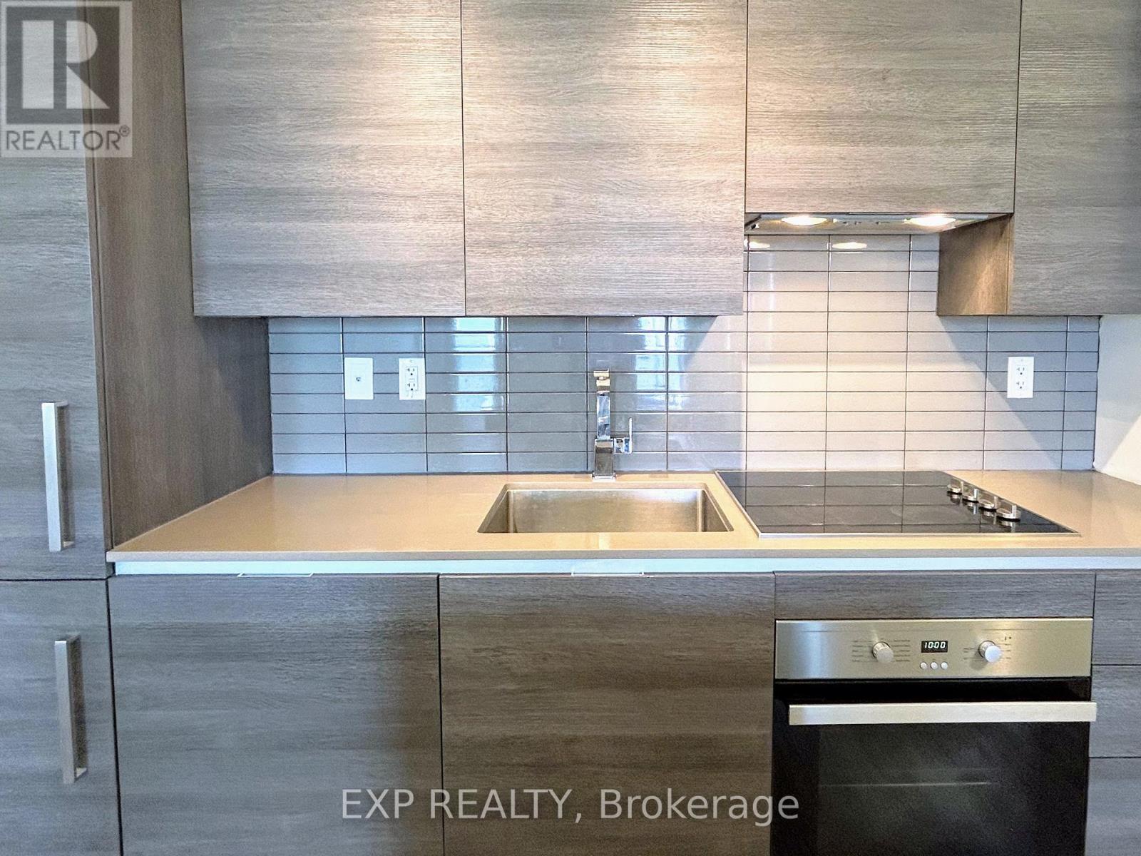 A modern kitchen with a stainless steel oven and a sink.
