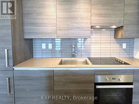 A modern kitchen with a stainless steel oven and a sink.