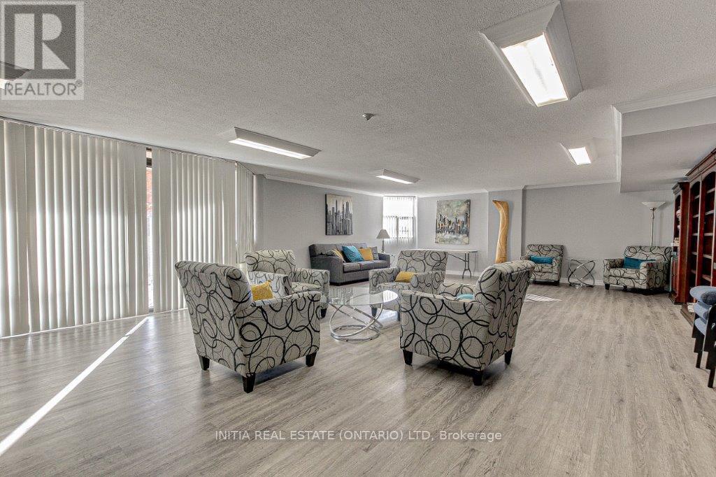 A living room with a grey sofa set and wooden flooring.