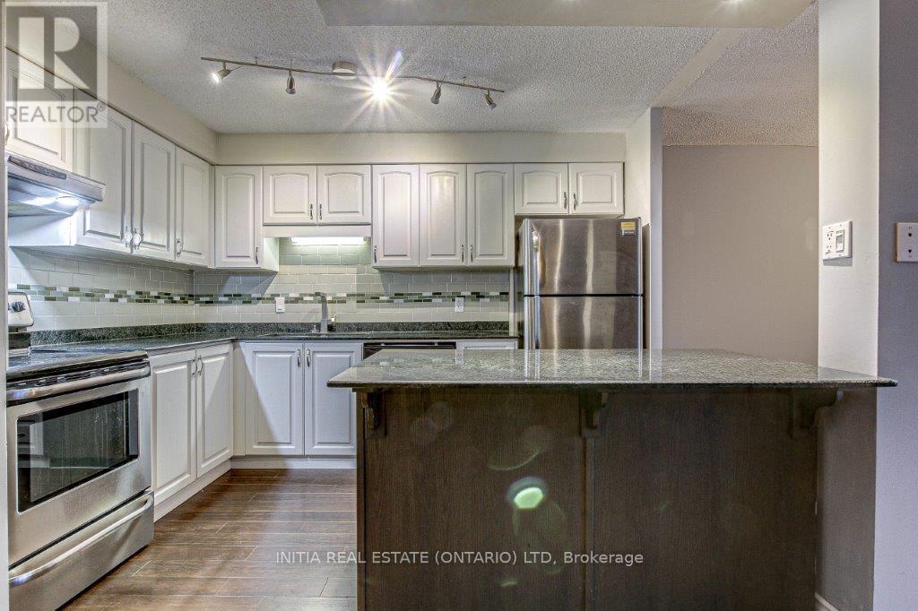 A kitchen with stainless steel appliances and wooden cabinets.