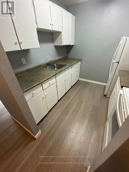 A kitchen with white cabinets and a wooden floor.