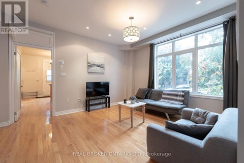 A living room with a grey couch and a wooden floor.