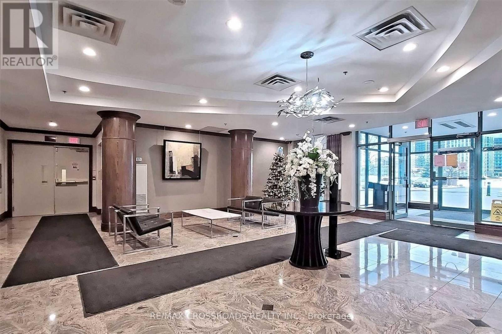 A large, well-lit lobby with a marble floor and a chandelier.