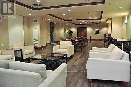 A living room with white furniture and a wooden floor.