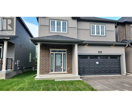 A house with a grey garage door and a brick wall.