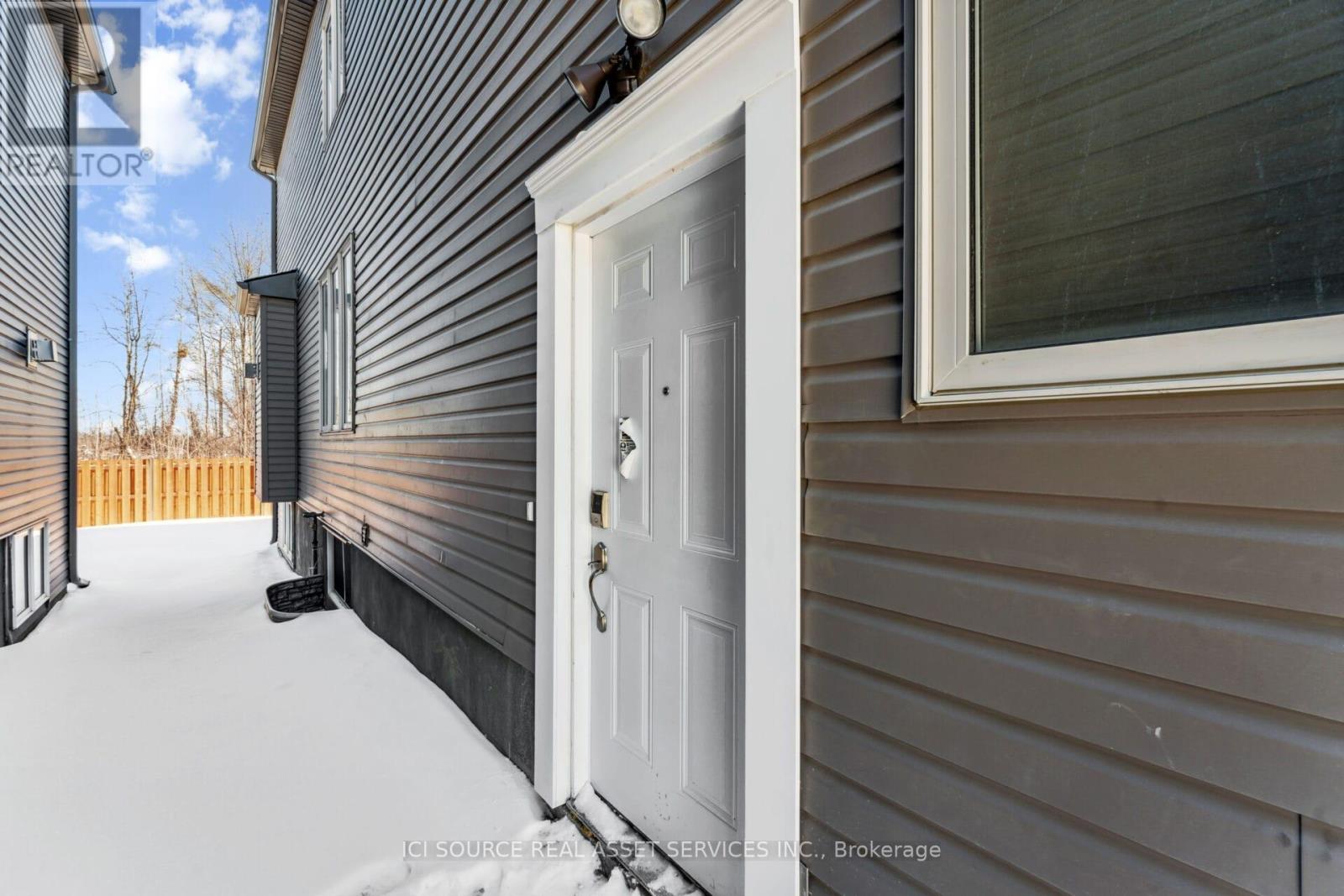 A white door is on the left side of a house.