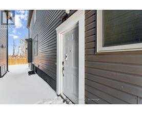 A white door is on the left side of a house.