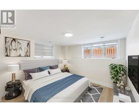 A bedroom with a bed, a lamp, a plant, and a painting on the wall.