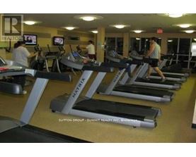 A gym with treadmills and people using them.