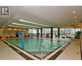 A large indoor swimming pool with a blue pole in the middle.