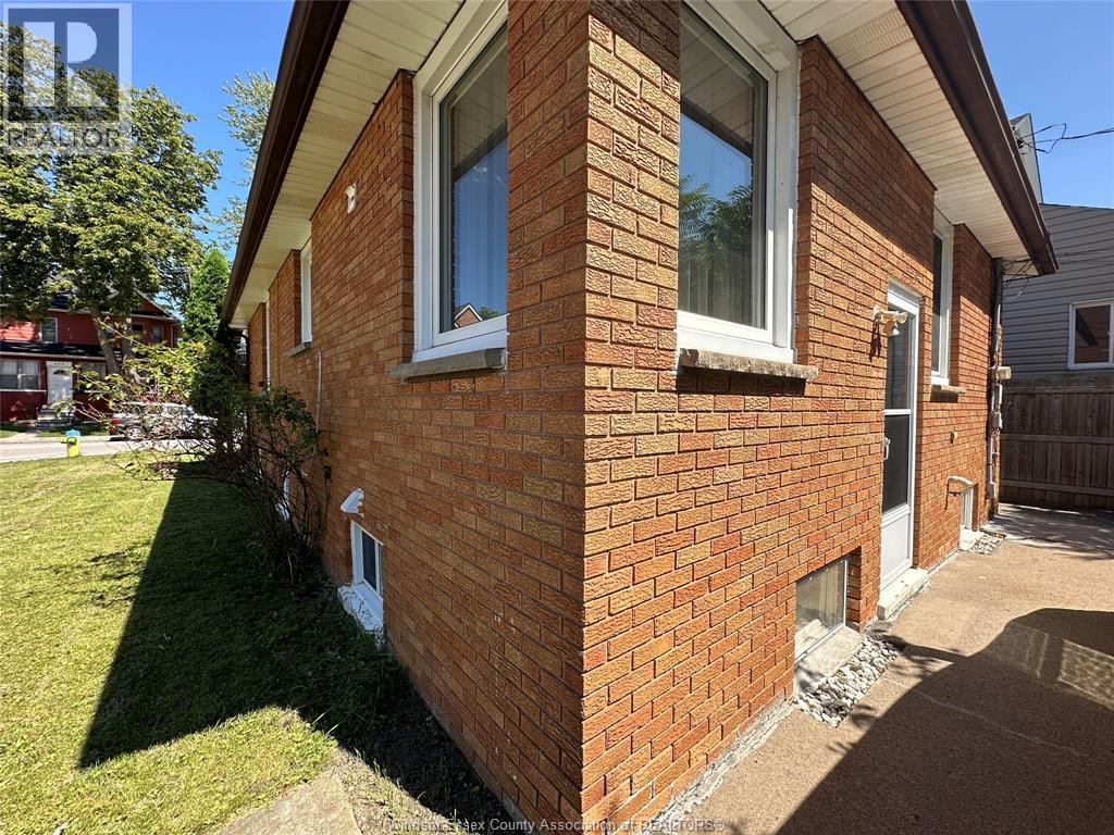 A red brick house with a white window and a door.