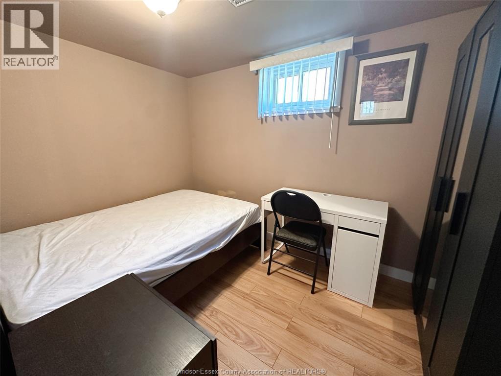 A bedroom with a bed, desk, and chair.