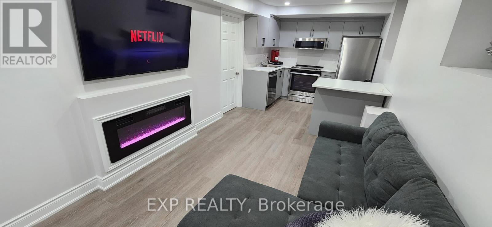A modern living room with a flat screen TV displaying the Netflix logo.