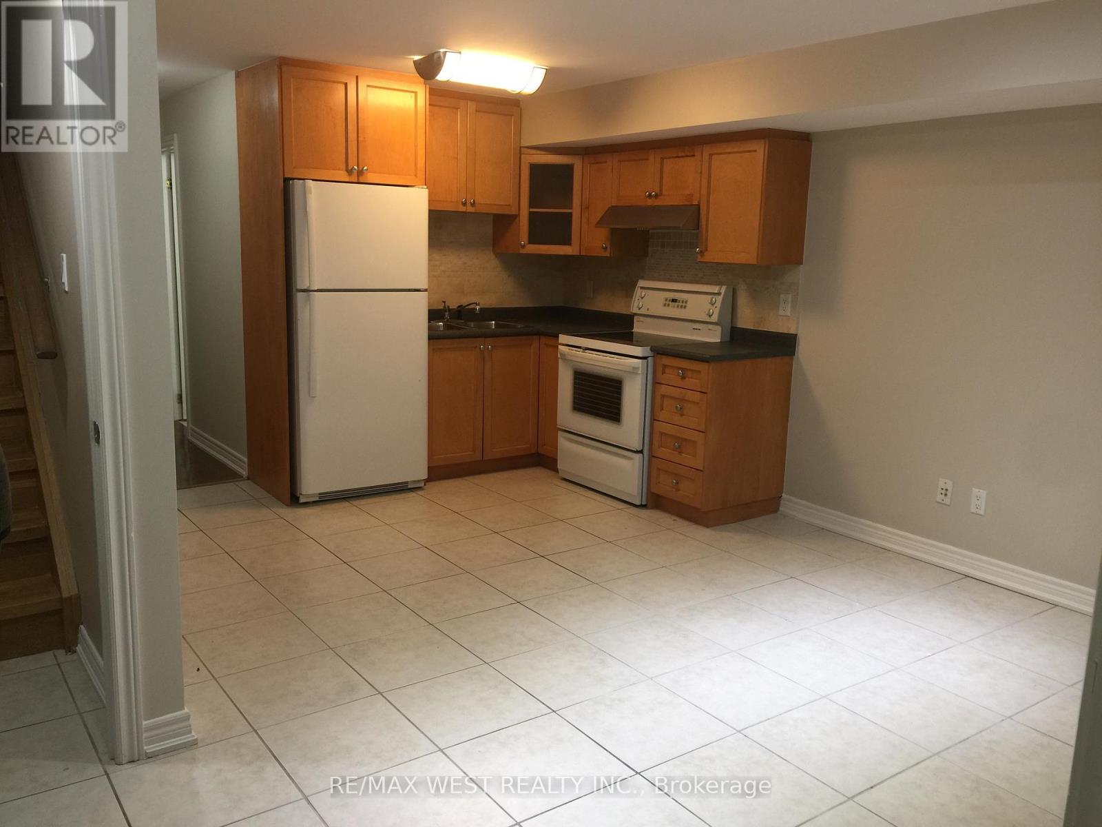 A kitchen with white appliances and wooden cabinets.