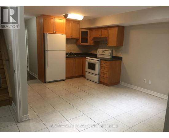 A kitchen with white appliances and wooden cabinets.