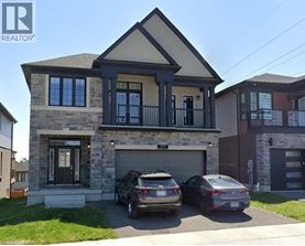 A two-story house with a garage and two cars parked in front.