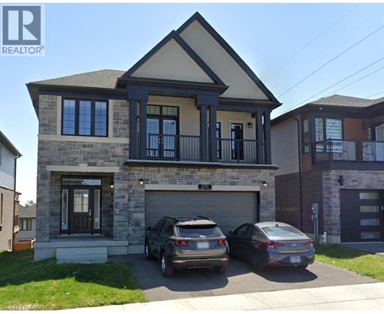 A two-story house with a garage and two cars parked in front.