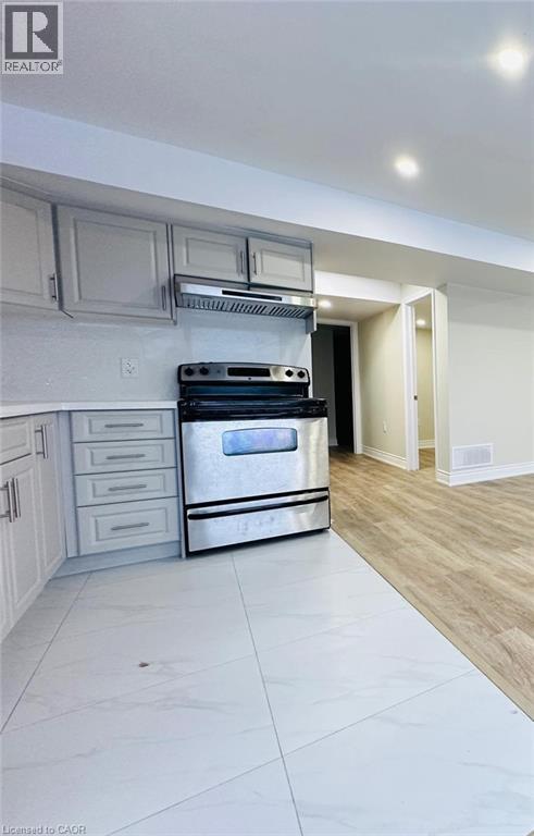 A modern kitchen with a stainless steel oven and white cabinets.