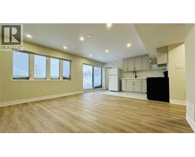 A spacious room with wooden flooring and a large window.