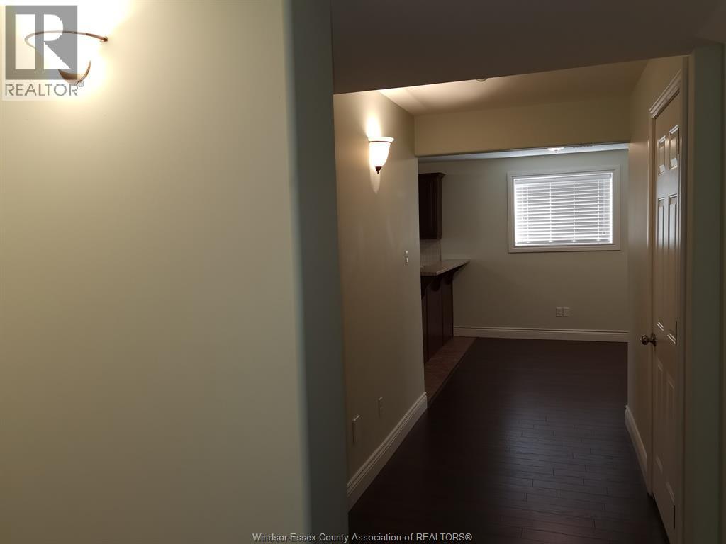 A hallway with a light on the wall and a door on the right.