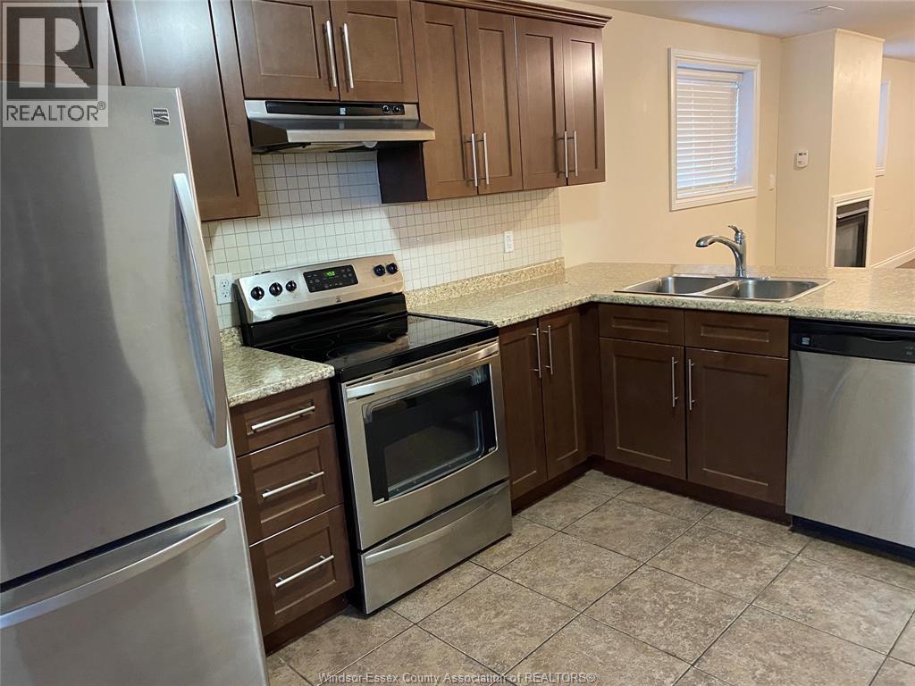 A kitchen with a stove top oven and a refrigerator.