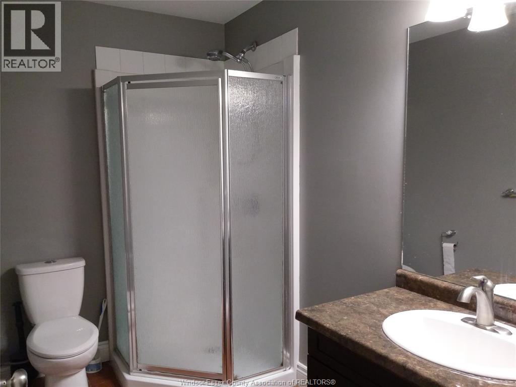 A bathroom with a toilet, sink, and shower.