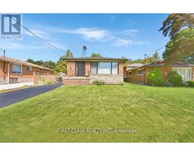 A real estate photo of a house with a lawn in front.