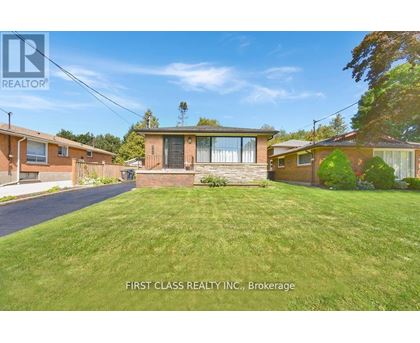 A real estate photo of a house with a lawn in front.
