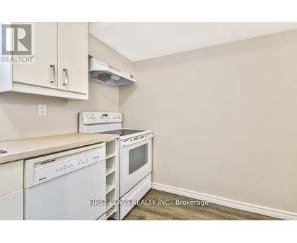 A kitchen with white appliances and cabinets.