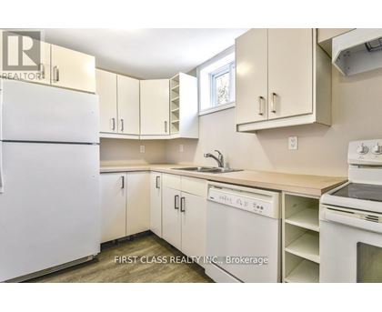 A kitchen with white appliances and cabinets.