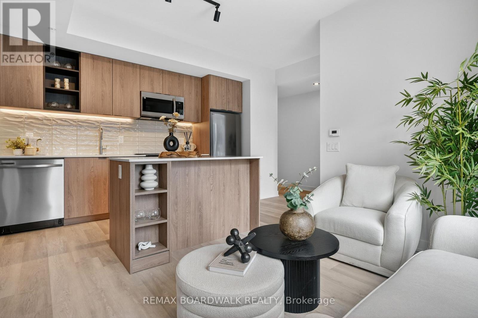 A modern kitchen with a wooden cabinet and a stainless steel refrigerator.