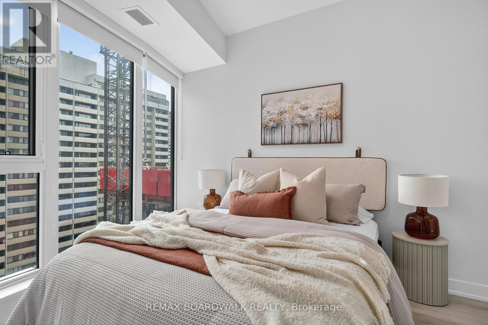 A bedroom with a large bed and a painting on the wall.