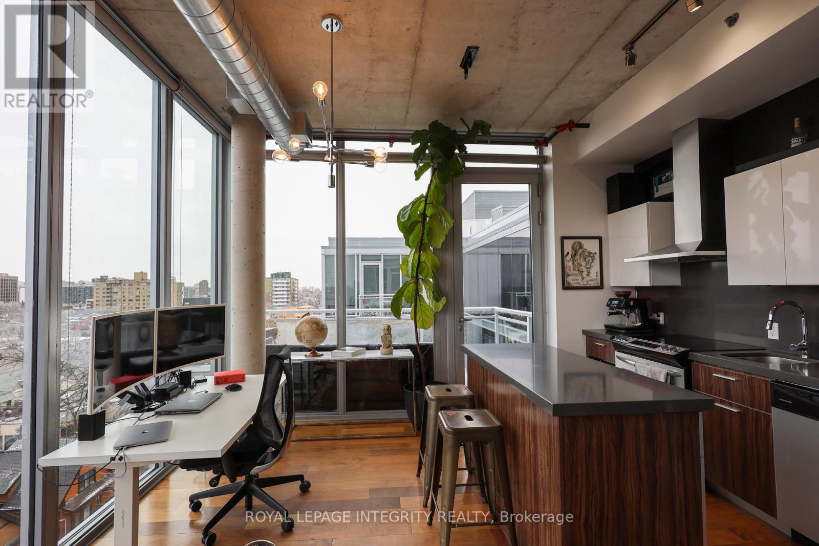 A modern kitchen with a desk and chair in the foreground.