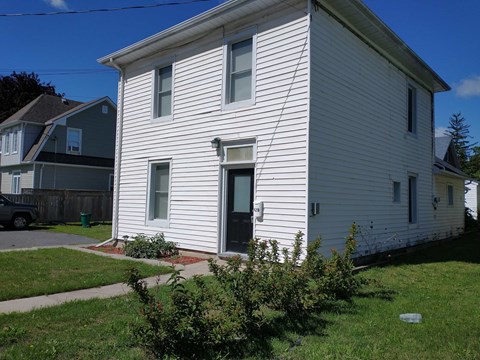 A white house with a black door and windows.