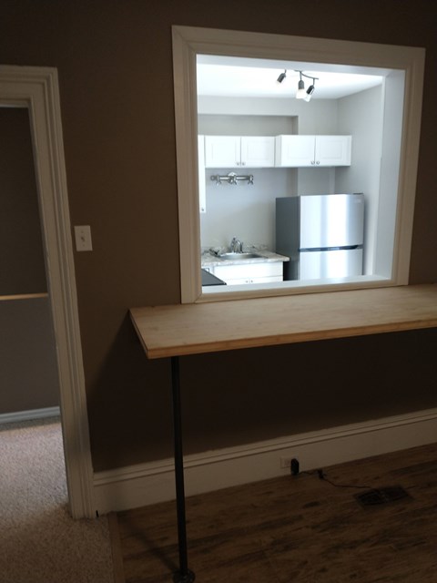 A mirror reflects a kitchen with a sink and refrigerator.