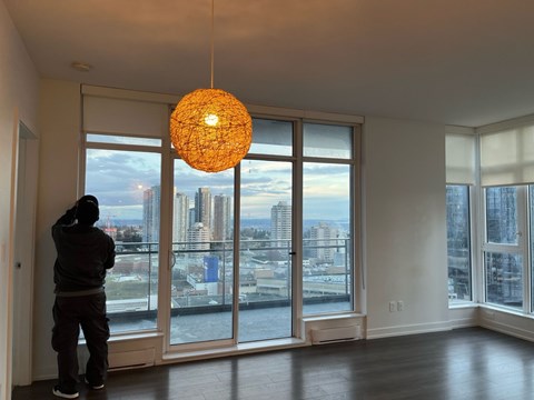 A man standing in a room with a view of the city.