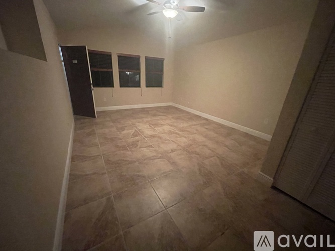 A room with a ceiling fan and tiled flooring.