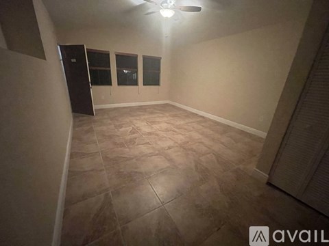 A room with a ceiling fan and tiled flooring.