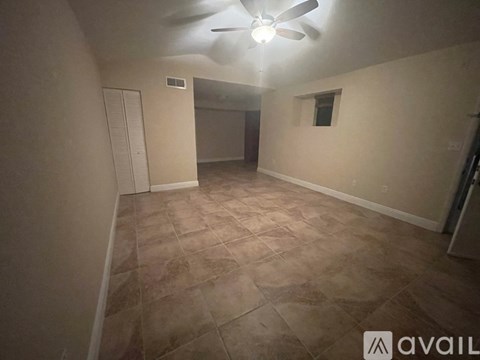 A room with a ceiling fan and tile flooring.