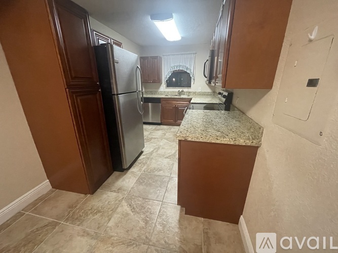 A kitchen with a refrigerator and cabinets.