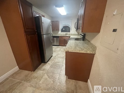 A kitchen with a refrigerator and cabinets.