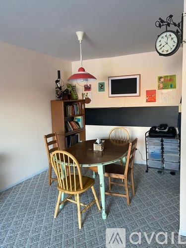A dining room with a round table and chairs.