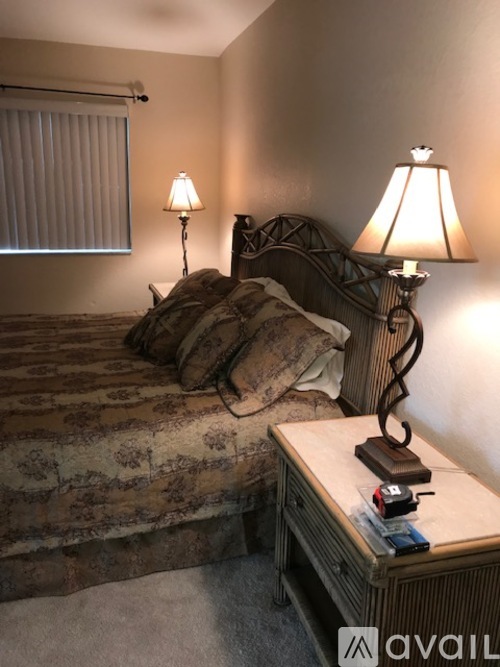 A bedroom with a bed, nightstand, and two lamps.