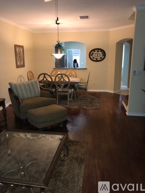 A living room with a glass coffee table and a couch.