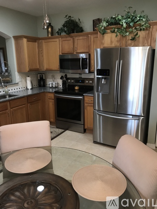 A kitchen with a stainless steel refrigerator and a stove top oven.