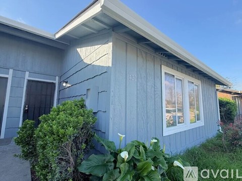 A house with a blue exterior and a window with a sign that says "available".