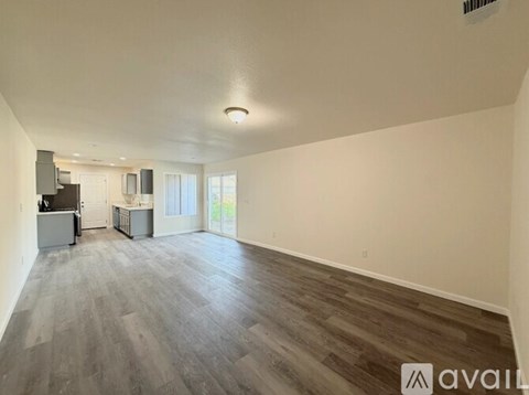 A spacious living room with a grey floor and white walls.