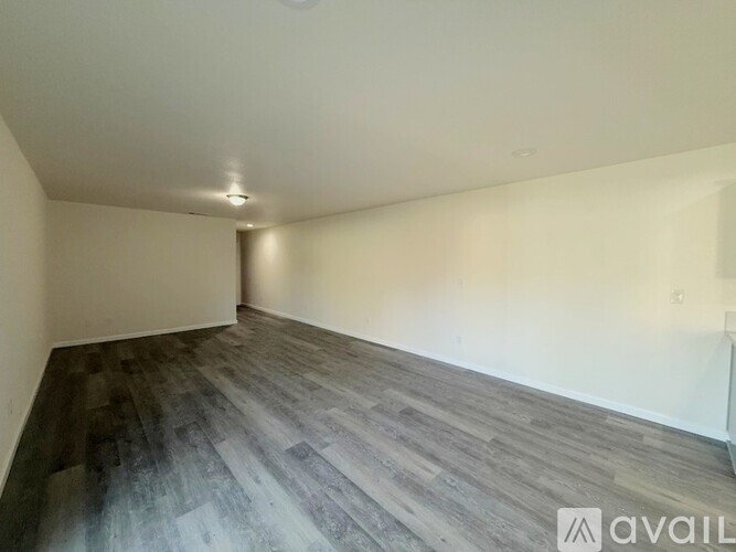A room with wooden flooring and white walls.